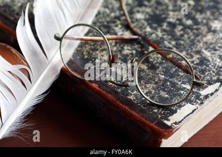 Vintage Stillleben. Alten Brille Buch in der Nähe von Federkiel Stockfoto