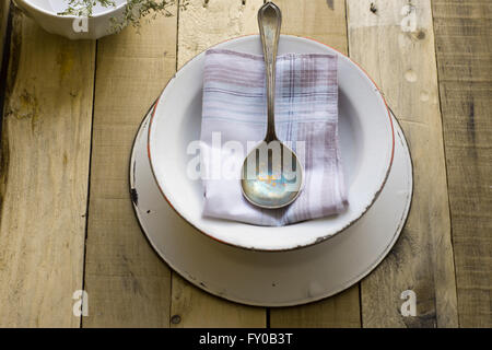 leere Suppenschüssel mit Löffel auf alten hölzernen Hintergrund Stockfoto