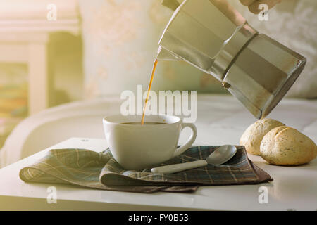Frau mit heißen Kaffee im Wohnzimmer seines Hauses in den Morgen Stockfoto