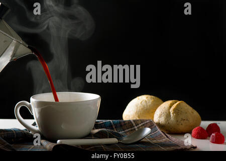 tätig in heißen Kaffee im Wohnzimmer von seiner Heimat, schwarzen Hintergrund Stockfoto