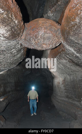 Ape Cave, Lavaröhre, Mt. St. Helens National Monument, Wanderer unter "The Meatball', Stück Basalt eingelegt Höhle Dach Stockfoto