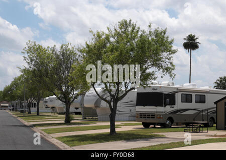 Ein Wohnmobil, mehrere Sattelkupplung Anhänger und Wohnmobile geparkt in Zeile in einem Wohnmobil/RV Resort im Süden von Texas, USA. Stockfoto
