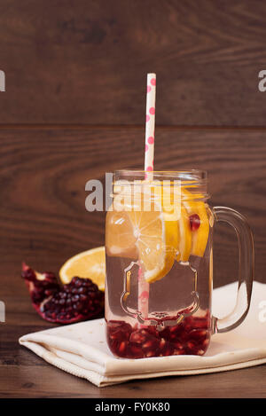Hausgemachte Limonade mit Granatapfel. Fruchtwasser, gesunde Entgiftung. Zitrone und Granatapfel auf Holz Hintergrund. Stockfoto