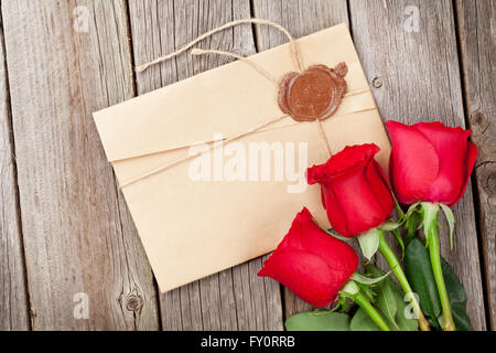 Liebe Brief und rote Rosen auf Holztisch. Valentinstag-Konzept Stockfoto