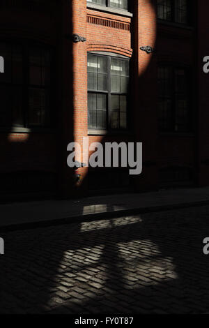 Sonnenstrahl trifft ein Backsteingebäude in einer DUMBO-Straße in Brooklyn Stockfoto