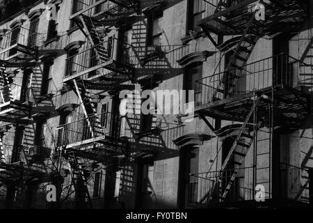 Feuerleitern auf alten Backstein-Mietshaus auf Stanton Street Lower East Side, in New York City. Monochrom, schwarz und weiß. Stockfoto