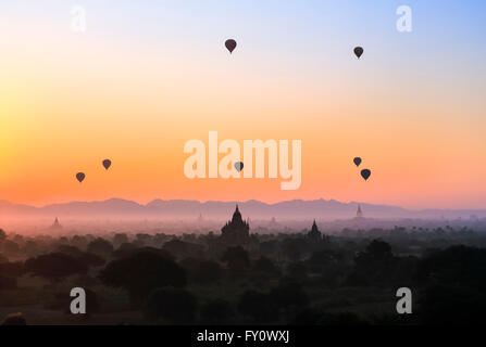 Heißluftballons über Old Bagan mit farbenfrohen Sonnenaufgang Himmel, nebligen Thatbyinnyu Phaya und andere Tempel-Silhouetten, Myanmar (Burma) Stockfoto