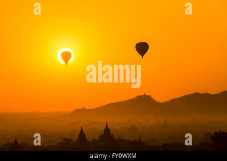 Heißluftballons über die aufgehende Sonne am Old Bagan in der Dämmerung und Nebel Thatbyinnyu Phaya, Myanmar (Burma) Stockfoto