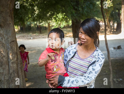 Frau trägt ihr Baby Sohn in einem Dorf auf dem Irrawaddy Fluss, Myanmar (Burma) Stockfoto