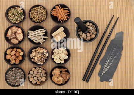 Traditionelle chinesische Medizin mit Akupunkturnadeln und Stäbchen über Bambus Hintergrund. Stockfoto