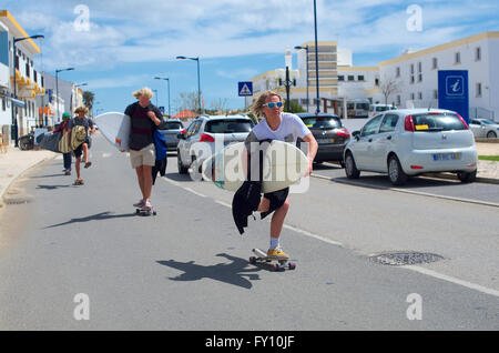 Blonde Surfer Skateboard die Straße hinunter, Sagres Portugal Stockfoto