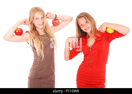 Zwei Mädchen halten Äpfel auf ihren Bizeps. Isoliert auf weiss. Stockfoto