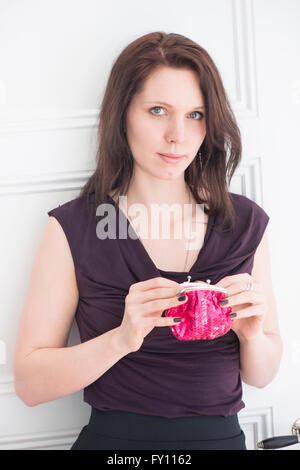 Porträt der Frau hält eine rote Geldbörse Lifestyle Bild der jungen Frau im schwarzen Kleid zeigt stolz Zuversicht und Entschlossenheit. Stockfoto