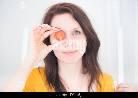 Frau mit Miniatur-Basketball. Ein Lifestyle-Bild zeigt eine unbeschwerte, selbstbewusste Frau und Sport-Konzept. Stockfoto