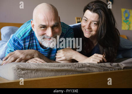 Porträt von glücklich älteres Paar auf Bett zu Hause Stockfoto