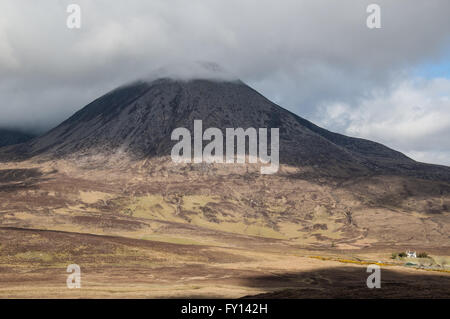 Kargen schottischen Berg mit der Spitze in Wolken bedeckt. Weiße Häuschen an der Unterseite. Stockfoto