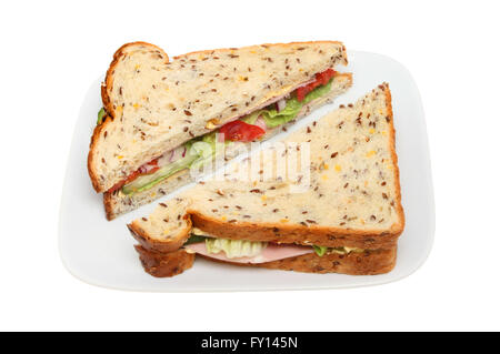 Schinken-Salat-Sandwich in Soja und Leinsamen Brot auf einem Teller isoliert gegen weiß Stockfoto
