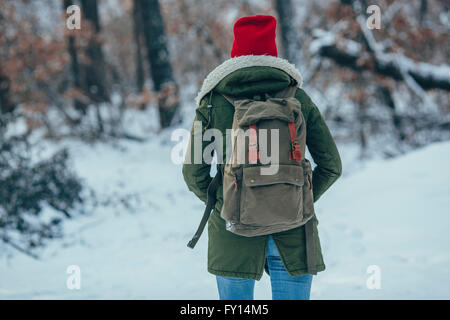 Rückansicht des jungen Frau mit Rucksack stehen auf Schnee bedeckt Feld Stockfoto
