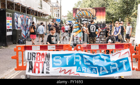 Junge vor einem großen anzeigentafel Förderung der Urban Art Street Festival findet jedes Jahr in den Straßen von Brixton. Stockfoto