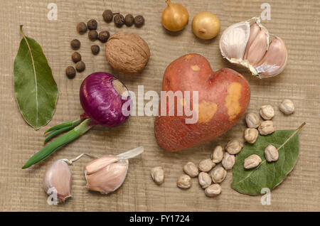 Rohe Kartoffeln und Gewürzen, auf die alte hölzerne Oberfläche. Stockfoto