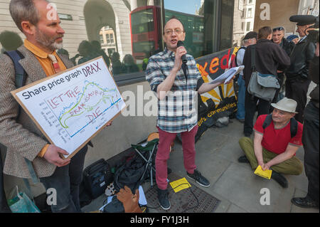 London, UK. 20. April 2016. Pete Deane von Biofuelwatch UK liest einige relevante Auszüge aus Literatur einschließlich von James Joyce außerhalb der Drax AGM und Duncan Gesetz gilt ein Plakat mit der steilen Rückgang der Aktienkurse seit Januar 2014. Der Protest Drax heruntergefahren werden gefordert und Aktionäre zurückziehen, da die Umstellung auf importierte Biomasse ihr Geld und den Planeten riskieren ist gewarnt. Subventionen für die Nutzung von Biomasse sind bestimmte geschnitten werden, zumal Studien seine CO2-Ausstoß zeigen um 3 Mal Kohle sein. Peter Marshall/Alamy Live-Nachrichten Stockfoto