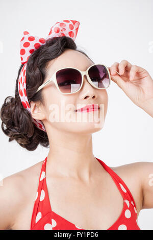 Porträt des jungen lächelnde Frau im retro-Stil tragen und Sonnenbrillen zu berühren Stockfoto