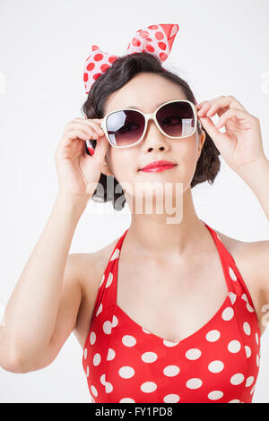 Porträt des jungen lächelnde Frau im retro-Stil tragen eine rührende ihre Sonnenbrille Stockfoto