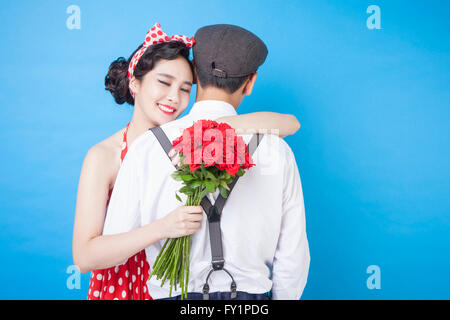 Porträt des jungen lächelnde Frau mit einem Blumenstrauß im Retro-Stil, die Umarmung eines Mannes, die Augen schließen Stockfoto