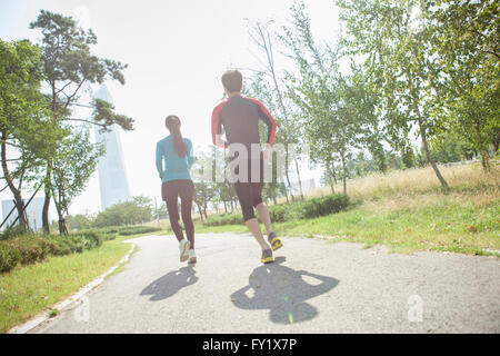 Darstellung eines Paares in Sportbekleidung Joggen im Park zurück Stockfoto