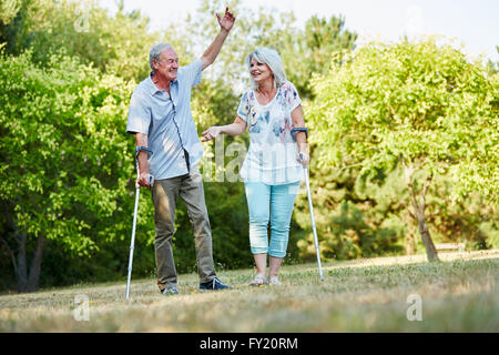 Gerne älteres Paar auf Krücken Spaß im Park im Sommer Stockfoto