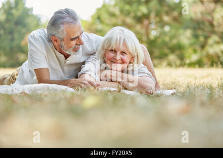 Gerne älteres Paar in Liebe entspannt auf die Gras im Sommer Stockfoto