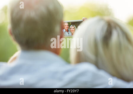 Älteres Paar nimmt ein Selbstporträt mit ihrem Smartphone in der Natur Stockfoto