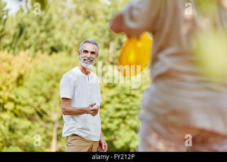 Älteres Paar spielt mit einer Frisbee in der Natur im Sommer Stockfoto