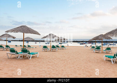Strand mit liegen und Sonnenschirmen Stockfoto