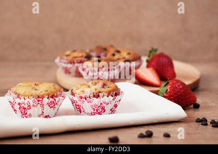 Erdbeeren und Schokolade Chip Muffins auf hölzernen Hintergrund Stockfoto