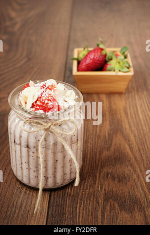 Chia-Samen-Pudding mit Erdbeeren, Bananen, Mandeln und Kokosnuss. Dunklem Holz Stockfoto