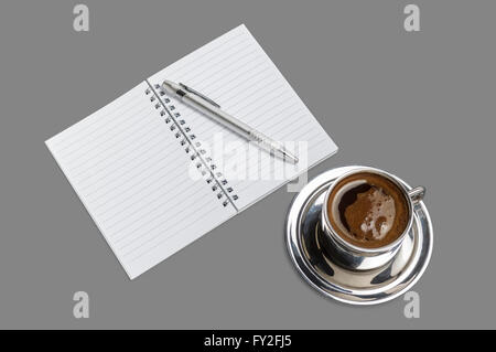 Kaffeebecher mit offenen leeren Notizbuch und Bleistift auf grauem Hintergrund isoliert. Stockfoto