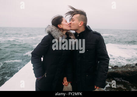 Liebevolle junge Brautpaar stehend auf Pier am Meer und leidenschaftlich küssen. Wunderbare Flitterwochen Stockfoto