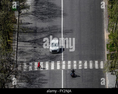 Auto und Motorrad warten auf Frau nachzutun Straße am Zebrastreifen, Paris, Frankreich. Stockfoto