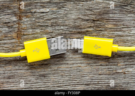 Gelbe USB-Kabel auf Holztisch, Close-Up-Ansicht Stockfoto