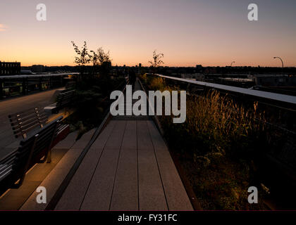 Eine nach Westen beleuchtet Gehweg auf der High Line in der Abenddämmerung in New York City. Stockfoto