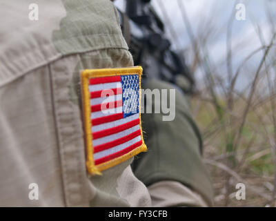 US-Soldat in Aktion - patch Flagge, Nahaufnahme und Gewehr auf den Hintergrund Stockfoto