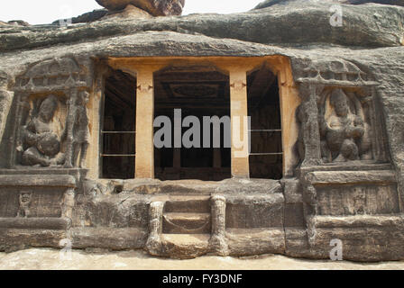 Vorderansicht des Ravanaphadi Fels gehauenen Tempel, Aihole, Bagalkot, Karnataka, Indien. Zwei Kubera Dwarpalas beiderseits der ma Stockfoto