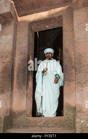 Priester mit einem Kreuz vor der Monolithic Felsen gehauene Kirche Bete Giyorgis (Heiliger Georg), Lalibela, Äthiopien Stockfoto