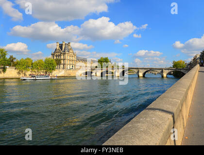 Dem linken Ufer der Seine in Paris gegenüber dem Jardin des Tuileries mit der Pont Royal Louvre und einem Bateau-Mouche. Stockfoto