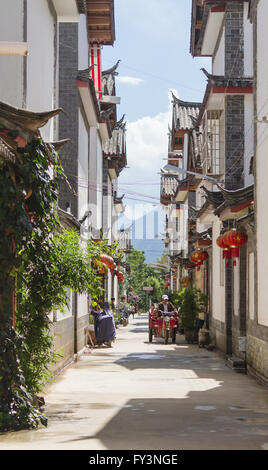 Mann fährt Dreirad durch Straße inmitten chinesischer traditioneller Architektur in Shuhe, Altstadt von Lijiang, Provinz Yunnan, China Stockfoto