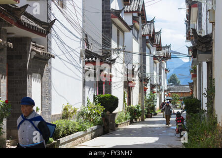 Die Menschen gehen über eine Straße inmitten chinesischer traditioneller Architektur in Shuhe, Lijiang alte Stadt in der Provinz Yunnan, China Stockfoto