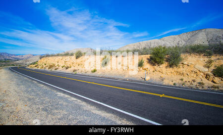 Schwarzer Asphalt Wüste Autobahn unter strahlend blauem Himmel in California. Stockfoto