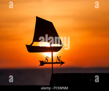 Silhouette eines Bootes auf eine Wetterfahne gegen den Sonnenuntergang mit dem Meer im Hintergrund, Oland / Öland, Schweden. Skandinavien. Stockfoto