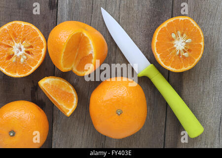 Mandarinen und Acryl Messer platziert auf dem alten Holzboden, Design-Konzept für über gesunde Lebensmittel. Stockfoto